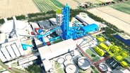 Modellbild von dem Zementwerk der Firma Holcim mit dem neuen Ofen in blau und weiteren Gebäuden in grün simuliert. © Screenshot 