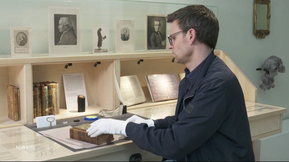 Der Kurator Tim Kunze in der Ausstellung über Immanuel Kant mit Gegenständen des berühmten Philosophen. © Screenshot 