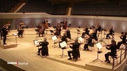 Musiker:innen auf der Bühne der Elbphilharmonie. © Screenshot 