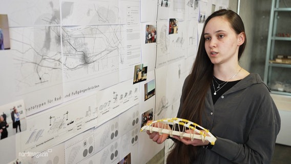 Eine Studierende hält das Model einer Brücke. © Screenshot 