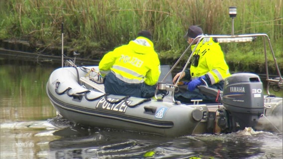 Zwei Männer auf einem Polizeiboot, den Blick aufs Wasser gerichtet. © Screenshot 