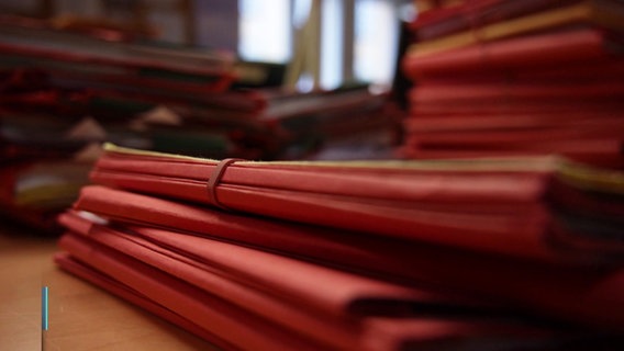 Stapel von roten Akten in der Nahaufnahme. © Screenshot 