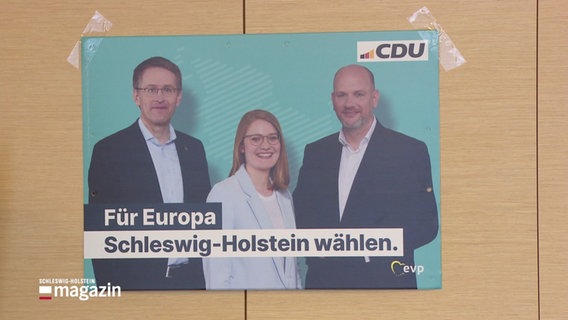 Ein Wahlplakat der CDU ist mit Tesastreifen an einer Wand befestigt. © Screenshot 