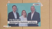 Ein Wahlplakat der CDU ist mit Tesastreifen an einer Wand befestigt. © Screenshot 