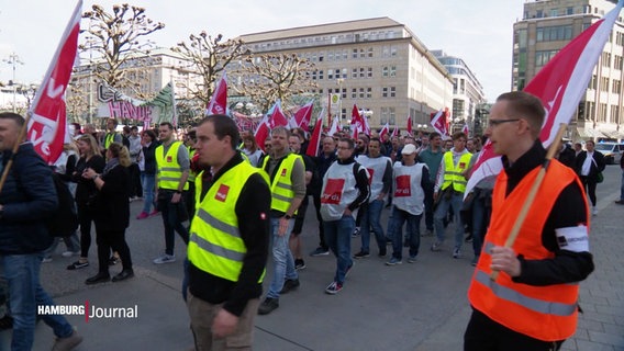 Demonstrierende mit verdi-Fahnen und Warnwesten in der Hamburger Innenstadt. © Screenshot 
