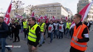 Demonstrierende mit verdi-Fahnen und Warnwesten in der Hamburger Innenstadt. © Screenshot 