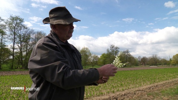 Der Gärtner Jens Wöbb mit einem Strauß Maiglöckchen. © Screenshot 