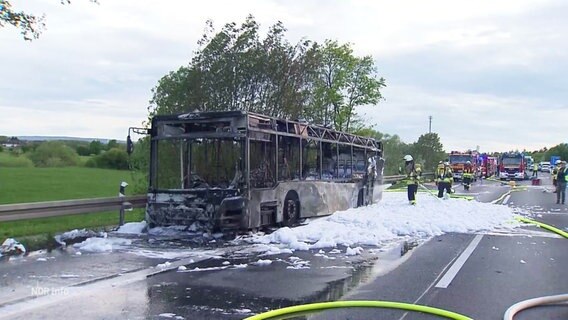 Ein ausgebrannter Reisebus steht auf der A2 nahe Garbsen. © Screenshot 