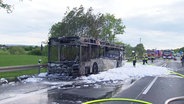 Ein ausgebrannter Reisebus steht auf der A2 nahe Garbsen. © Screenshot 