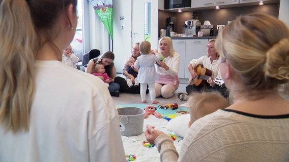 Mütter sitzen mit ihren Kindern im Kreis und lernen spielerisch die deutsche Sprache. © Screenshot 