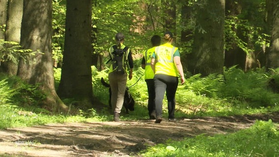 Ein Suchteam mit Spührhund im Wald. © Screenshot 