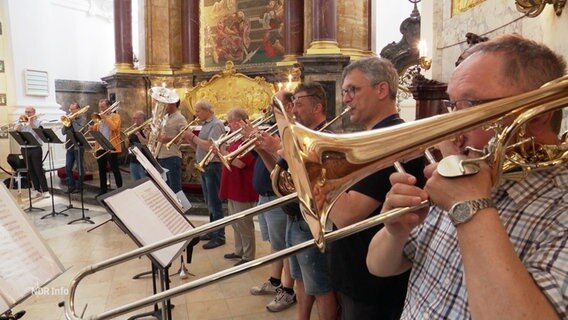 Eine Gruppe Blechbläser in einer Kirche, von der Seite fotografiert. © Screenshot 