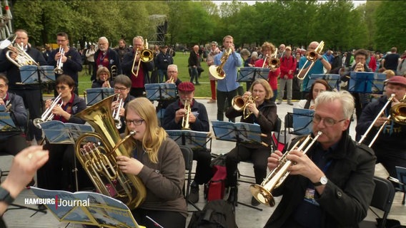 Musizierende mit Blechblasintsrumenten im Park. © Screenshot 