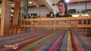 Textildesignerin Linda Detering sitzt an einem traditionellen Webstuhl. © Screenshot 