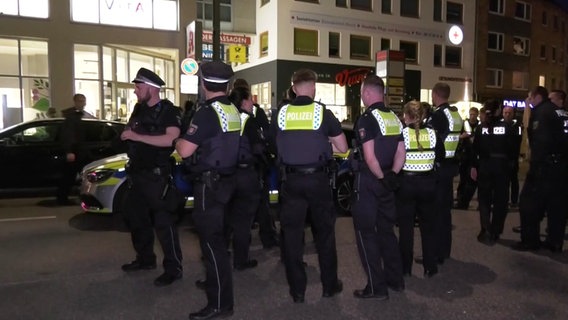 Eine Gruppe von Polizistinnen und Polizisten stehen auf einer Straße. © Screenshot 