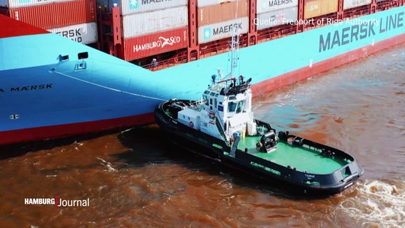 Ein Schlepper neben einem Containerschiff. (Quelle: Freeport of Riga Authority) © Screenshot 
