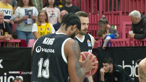 Der Basketball-Spieler King hält den Ball in den Händen. © Screenshot 