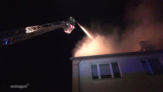 Die Feuerwehr löscht mithilfe einer Drehleiter den brennenden Dachstuhl. © Screenshot 