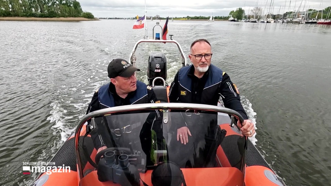 Zwei Wasserpolizisten sind in einem Motorboot im Einsatz.
