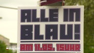 "Alle in Blau!" steht auf einem Schild. © Screenshot 