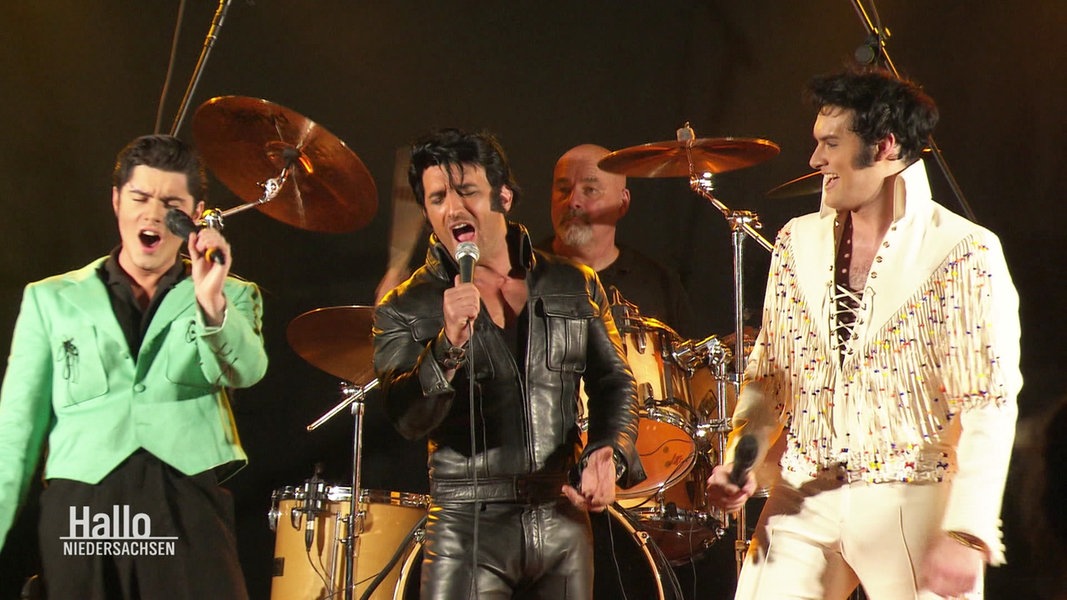 Dre Elvis Tribute Artists stehen gemeinsam auf einer Bühne.
