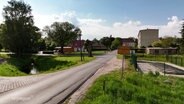 An einer kleinen Straße steht das Ortsschild von Fincken. © Screenshot 