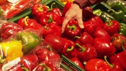 Eine Hand greift nach einer roten Paprike in der Gemüseabteilung. © Screenshot 