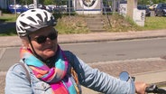 Eine Radfahrerin mit Sonnenbrille lächelt in die Kamera. © Screenshot 