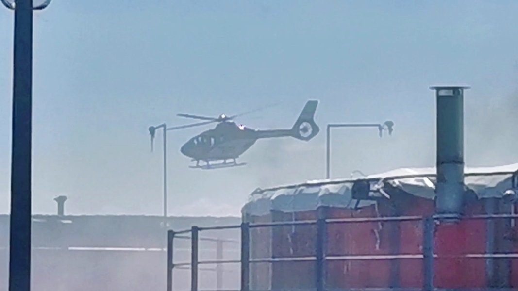 Ein Hubschrauber fliegt über einer brennenden Biogasanlage in Hevensen. 