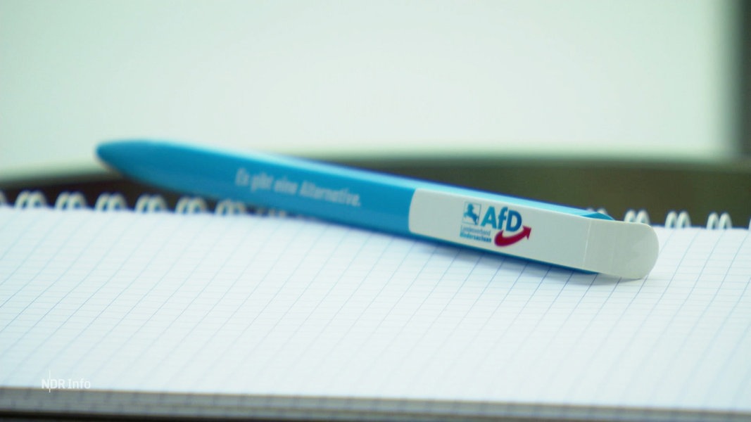 Auf einem Notizblock liegt ein Kugelschreiber mit AFD-Logo