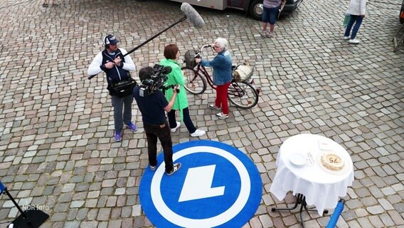 Ein Team des NDR befragt eine Frau mit Fahrrad auf der Straße. © Screenshot 
