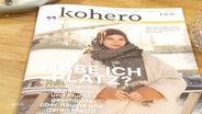 Eine Ausgabe des "Kohero"-Magazins liegt auf einem Tisch. Das Titelbild zeigt eine junge Frau mit Kopftuch und die Schlagzeile lautet "Habe ich Platz?". © Screenshot 
