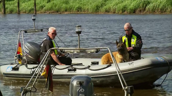 Zwei Polizeibeamte mit Spürhund auf einem Schlauchboot © Screenshot 