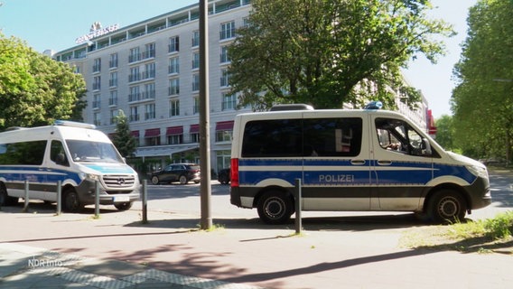 Zwei Einsatzwagen der Polizei stehen vor dem Hotel Grand Elysée. © Screenshot 