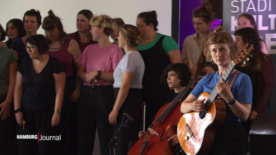 Eine Gruppe von Frauen musiziert gemeinsam auf einer Bühne. © Screenshot 