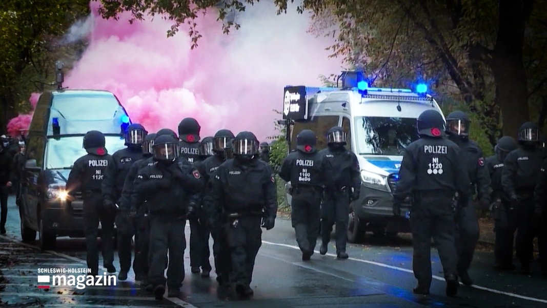 Viele Polizisten eskortiern einen Fan-Marsch von Fussballfans.