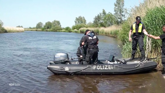 Mehrere Polizeibeamte befinden sich in einem Boot auf einem Gewässer. © Screenshot 