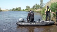 Mehrere Polizeibeamte befinden sich in einem Boot auf einem Gewässer. © Screenshot 