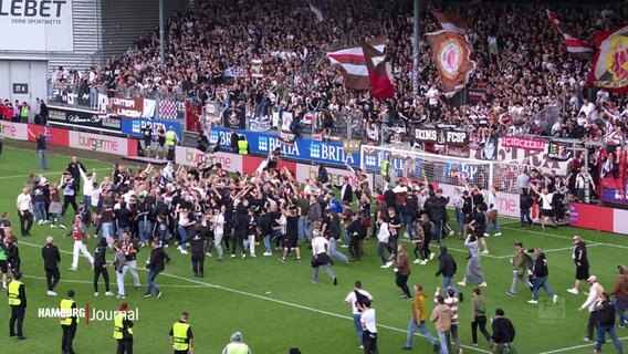 Fans des FC St. pauli stürmen nach einem Sieg das Spielfeld. © Screenshot 