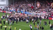 Fans des FC St. pauli stürmen nach einem Sieg das Spielfeld. © Screenshot 