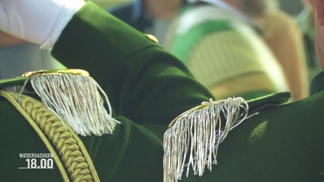 nahaufnahme: Goldene Epaulettem ziehren die Schultern grün uniformierter Vereinsschützen.