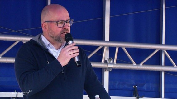 Steffen Beckmann spricht am Mikrofon bei einer Veranstaltung. © Screenshot 