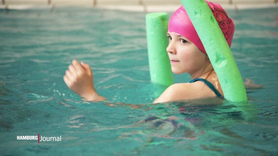 Ein Mädchen lernt mit einer Schwimmnudel das Schwimmen. © Screenshot 