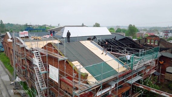 Luftaufnahme des Eisenbahnmuseums. Es ist von Baugerüsten umgeben, auf dem Dach stehen einige Arbeiter. © Screenshot 