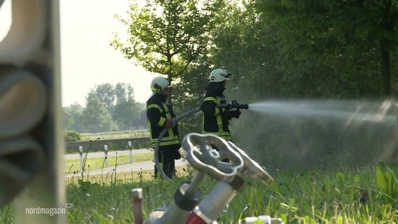 Zwei Feuerwehrleute bei einer Übung an einem Autobahnabschnitt. © Screenshot 