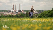 Aktivistin Clara Mayer läuft über eine Wiese, im Hintergrund die VW-Werke. © Screenshot 