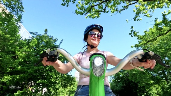 Eine Frau fährt mit einem grünen Fahrrad. © Screenshot 