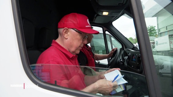 Ein Mann in roter Kleidung sitzt auf dem Beifahrersitz eines Lieferwagens. © Screenshot 
