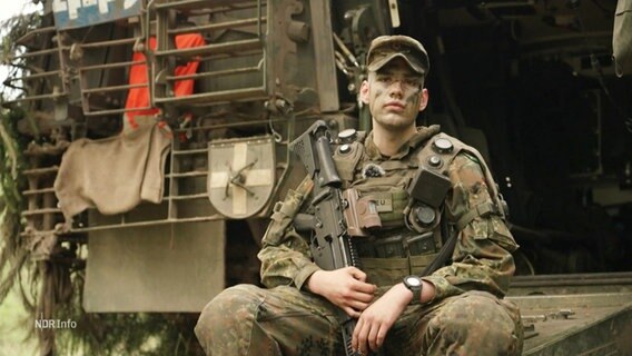 Ein Bundeswehrsoldat sitzt auf einem Militärfahrzeug. © Screenshot 