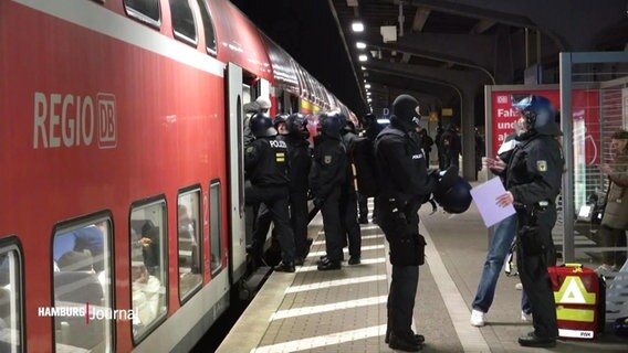 Polizeibeamte stehen an der Tür  eines Regionalzugs. © Screenshot 